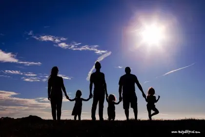 Family silhouette against a bright sky